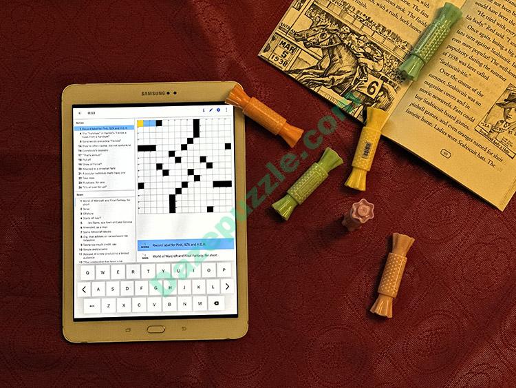 NYT crossword light theme tablet alongside book